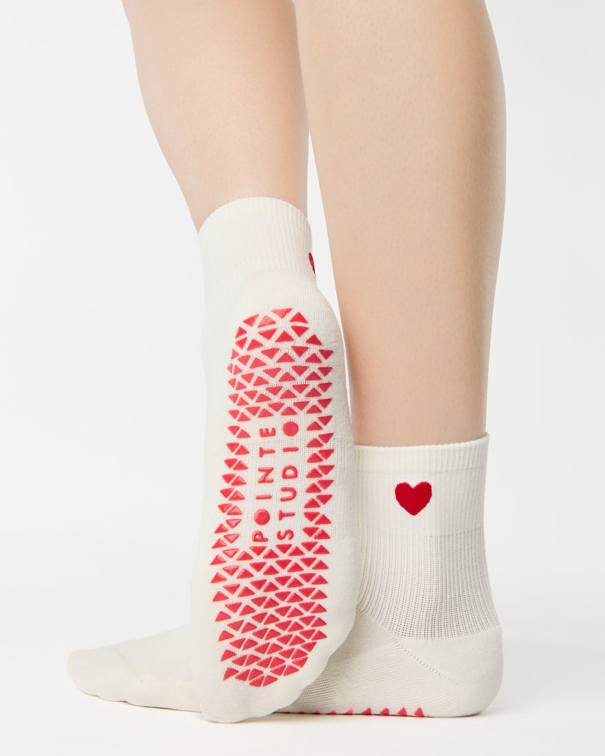 Billede af et par sokker "Love Full Foot" i farven Black fra Pointe Studio. Disse sokker har et hjerte på hælen og giver både komfort og stabilitet, ideelle til yoga og pilates.