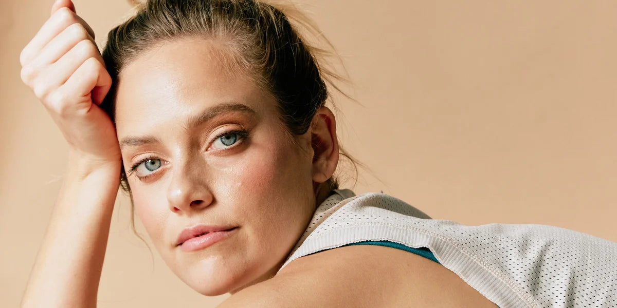 Nærbillede af en kvinde, som repræsenterer Pointe Studio’s æstetik og branding, med fokus på komfort og stil i træningstøj og sokker.⬤